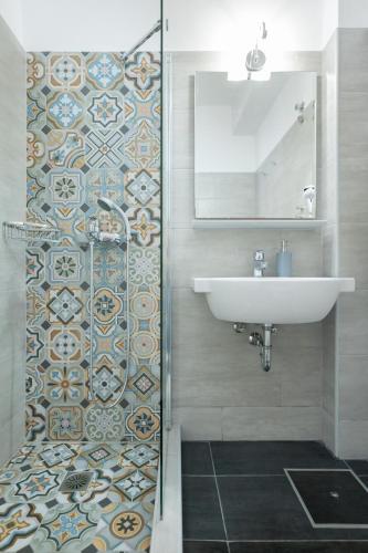 a bathroom with a sink and a mirror and a shower at Nondas Apartments in Lassi