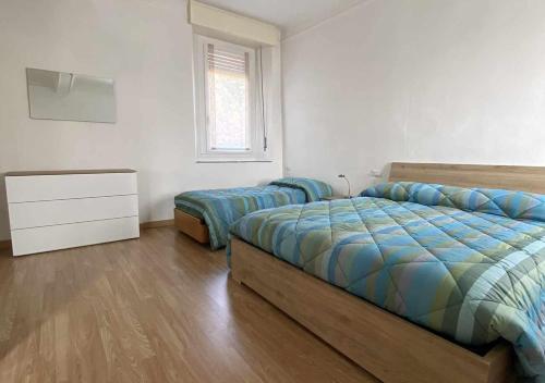 een slaapkamer met 2 bedden, een dressoir en een raam bij Casa Vacanza Amelia in Bosisio Parini