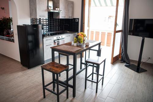 a kitchen with a table and stools and a refrigerator at CS LUXURY HOUSE in Lido di Ostia