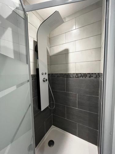 une douche avec une porte vitrée dans une salle de bain dans l'établissement Charmant 2 pièces avec terrasse proche centre ville - Parking Gratuit à proximité, à Lourdes