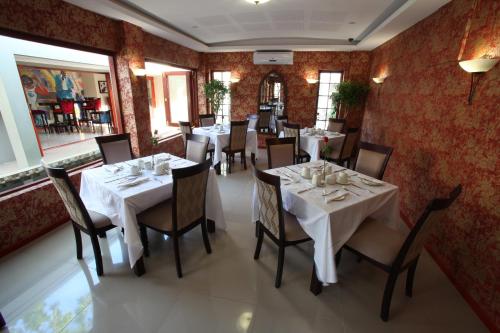 a dining room with tables and chairs in a restaurant at Park Place Boutique Guesthouse in East London