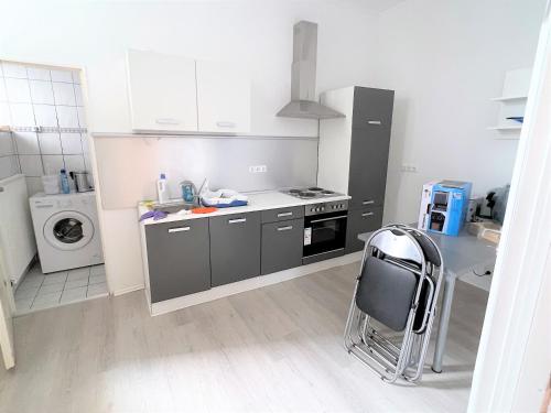 een keuken met een fornuis en een stoel. bij Wohnung in Düren Stadtmitte in Düren - Eifel