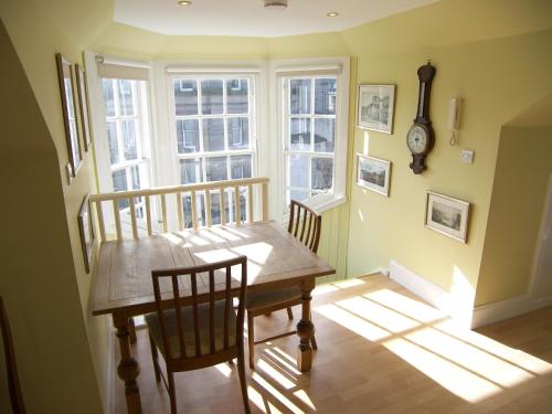 ein Esszimmer mit einem Tisch, Stühlen und einem Fenster in der Unterkunft CENTRAL Calton Hill What a view in Edinburgh
