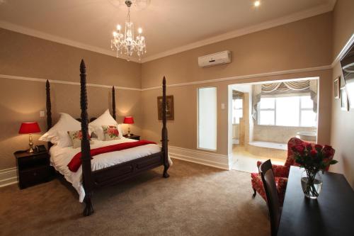 a bedroom with a bed and a chandelier at Park Place Boutique Guesthouse in East London