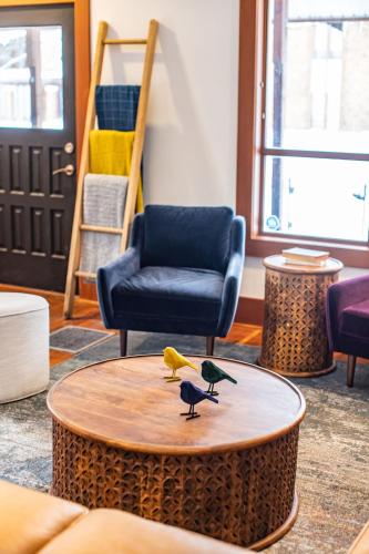 three birds sitting on a table in a living room at Mackenzie House by Revelstoke Vacations in Revelstoke