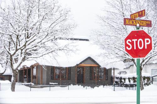 a stop sign in front of a house in the snow at Mackenzie House by Revelstoke Vacations in Revelstoke