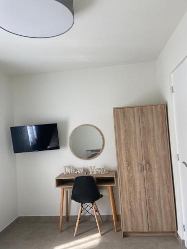 a desk with a mirror next to a cabinet at M & F HOUSE (παραλία Μαρκοπούλου Ωρωπού) in Oropós