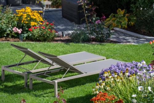 a couple of chairs sitting in the grass with flowers at Apartement Almhof Fiss in Fiss