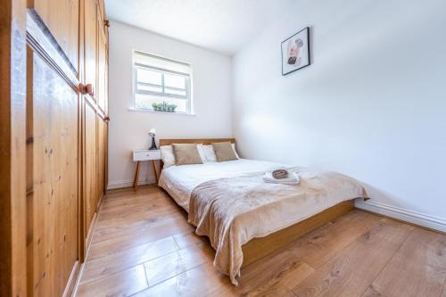 a small bedroom with a bed and a window at Comfortable 2 Bed Apartment Near Stansted Airport & Bishops Stortford in Bishops Stortford