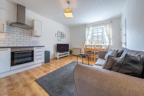 a living room with a couch and a kitchen at Comfortable 2 Bed Apartment Near Stansted Airport & Bishops Stortford in Bishops Stortford