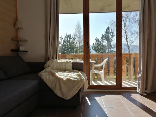 a living room with a couch and a sliding glass door at Appartement 2 Chambres au calme in Les Angles