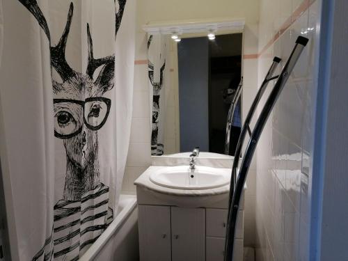a bathroom with a sink and a deer shower curtain at Appartement 2 Chambres au calme in Les Angles