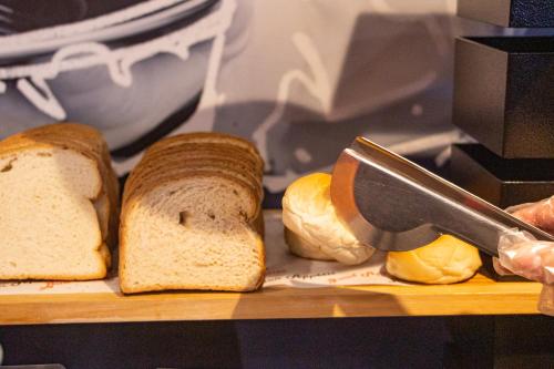 a cutting board with bread and a knife on it at ibis budget Curitiba Aeroporto in São José dos Pinhais
