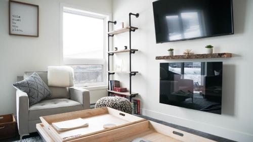 a living room with a couch and a tv at The Revy Den by Revelstoke Vacations in Revelstoke