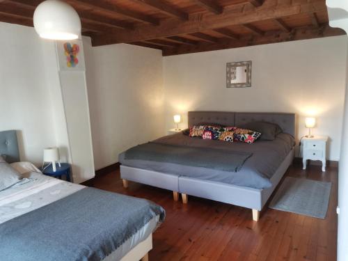 1 Schlafzimmer mit 2 Betten in einem Zimmer mit Holzböden in der Unterkunft Gite des Cotes de Sioule in Lisseuil