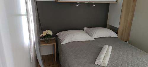 een bed met twee kussens in een kamer bij Mobile home Maria, Camp Baško Polje in Baška Voda
