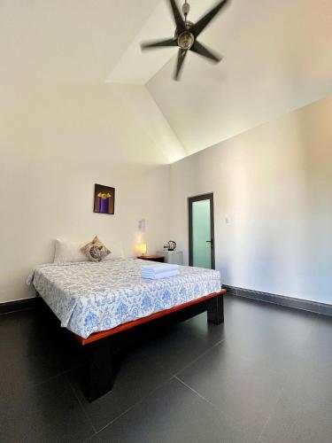 a bedroom with a bed with a ceiling fan at Catsen Bungalows & Pool Phan Thiet in Phan Thiet