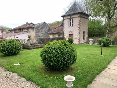 a house with a large bush in the yard at Le Château de Failloux, Piscine intérieure in Épinal
