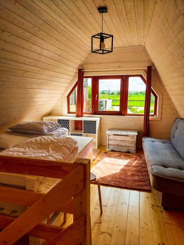 韋巴的住宿－Domki drewniane całoroczne Zielona Łeba，客房设有两张床、一张沙发和一个窗口。