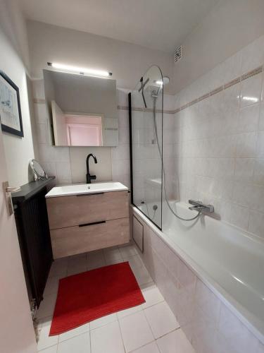 a bathroom with a tub and a sink and a shower at Casa Quatre-Mains Westende in Middelkerke