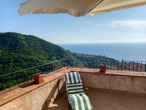 - deux chaises longues assises sur un balcon donnant sur l'océan dans l'établissement A Taverna Intru U Vicu, à Belmonte Calabro