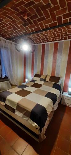 a bed in a room with a striped ceiling at Appartamento Lucia in Villanova dʼAsti