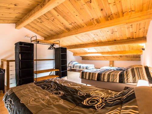 two beds in a room with wooden ceilings at Villa La Lauze in Labastide-de-Virac