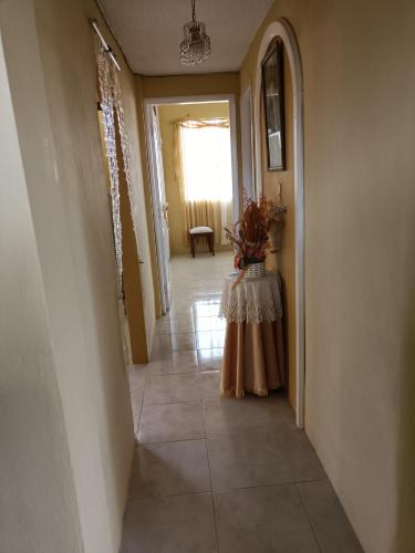 a hallway with a table with a vase of flowers on it at Casa de campo Pillaro - Activa in Píllaro
