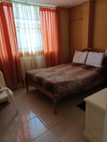 a bedroom with a bed and a window with curtains at Casa de campo Pillaro - Activa in Píllaro