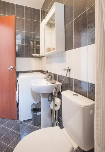 a bathroom with a white toilet and a sink at Apartments MaXhit in Tivat