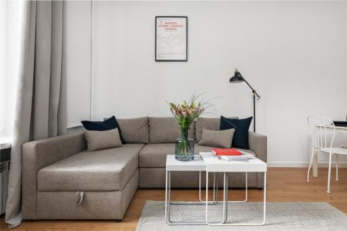 a living room with a couch and a table at oompH Warsaw Nowy Swiat Apartment in Warsaw