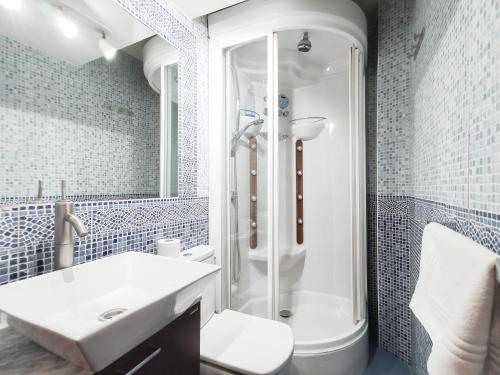 La salle de bains blanche est pourvue d'une douche et d'un lavabo. dans l'établissement Chueca Boutique, à Madrid