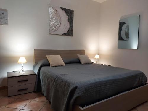 a bedroom with a bed with two lamps on it at B&B Villa Martina in Sardara