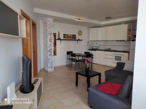 ein Wohnzimmer mit Couch und Küche in der Unterkunft cozy flat in Puerto del Rosario