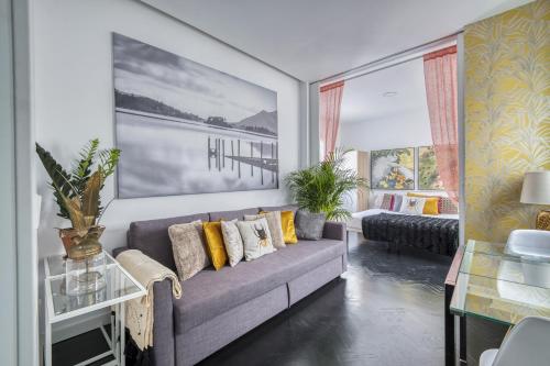 sala de estar con sofá gris y almohadas amarillas en El Rastro boutique, en Madrid