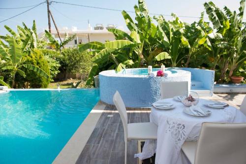 a table and chairs next to a swimming pool at Valantas Garden Suite in Lardos