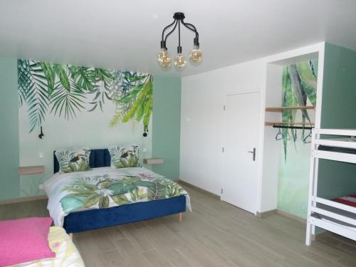 1 dormitorio con 1 cama con un mural tropical en la pared en La Ferme des Cerisiers, en Reventin-Vaugris
