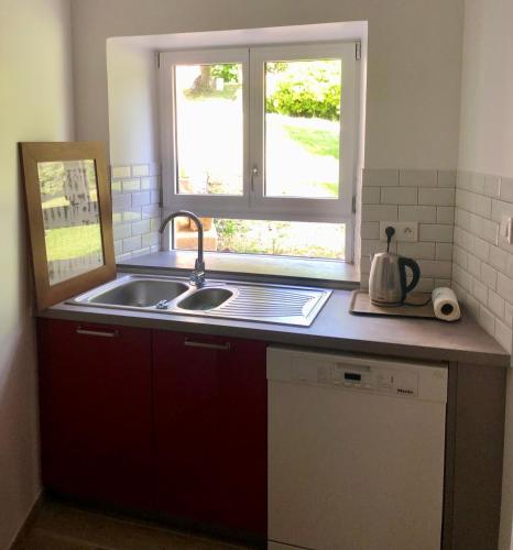 un comptoir de cuisine avec un évier et une fenêtre dans l'établissement L'abbaye du château du Vallier, à Langoiran