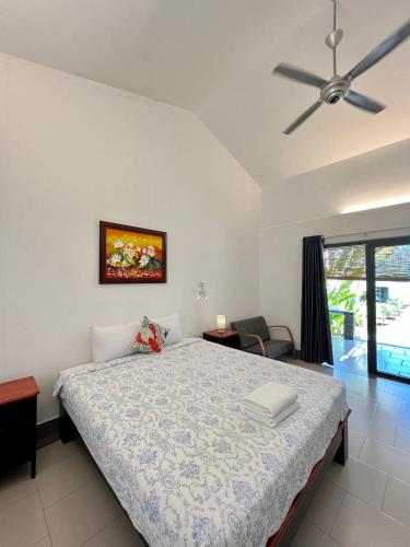a bedroom with a bed and a ceiling fan at Catsen Bungalows & Pool Phan Thiet in Phan Thiet