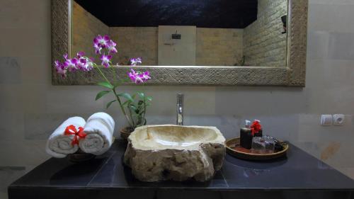 a bathroom sink with a rock on a counter at Villa D'Uma in Ubud