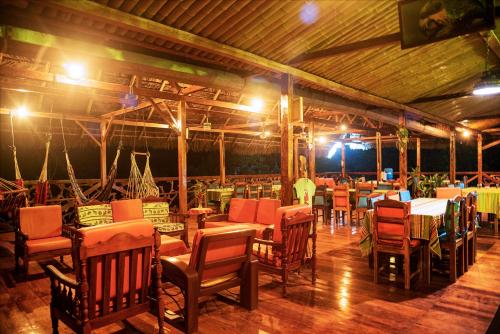 un comedor con mesas, sillas y luces en Yarina Eco Lodge, en Derna