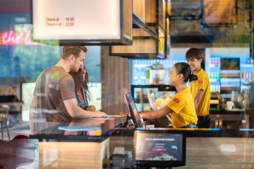 a man and a girl working at a counter in a restaurant at COSI Pattaya Wong Amat Beach - SHA Plus Certified in Pattaya North