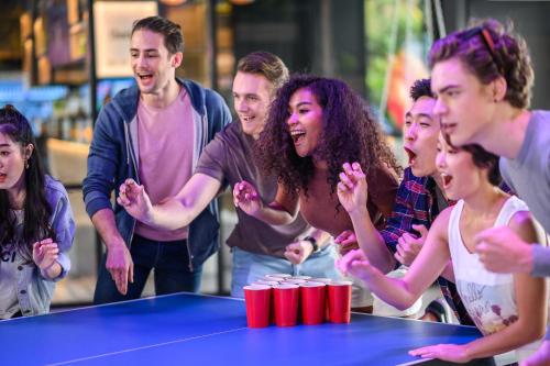 a group of people standing around a ping pong table at COSI Pattaya Wong Amat Beach - SHA Plus Certified in Pattaya North