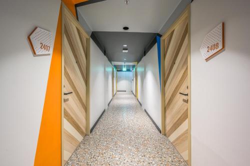 a long corridor with wooden doors and a hallway with a corridorngthngthngthngth at COSI Krabi Ao Nang Beach - SHA Plus in Ao Nang Beach
