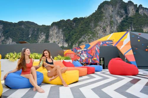 two girls sitting on bean bags in front of tents at COSI Krabi Ao Nang Beach - SHA Plus in Ao Nang Beach