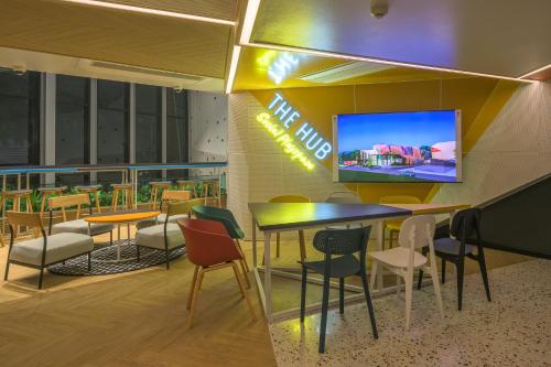a restaurant with tables and chairs and a tv at COSI Krabi Ao Nang Beach - SHA Plus in Ao Nang Beach
