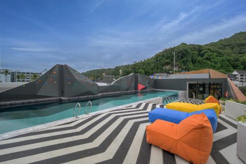 a swimming pool with two chairs on a roof at COSI Krabi Ao Nang Beach - SHA Plus in Ao Nang Beach