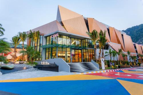 a building with palm trees in front of it at COSI Krabi Ao Nang Beach - SHA Plus in Ao Nang Beach