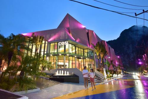 two women standing in front of a building at night at COSI Krabi Ao Nang Beach - SHA Plus in Ao Nang Beach
