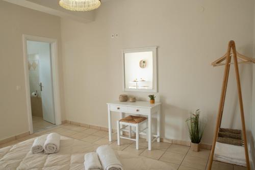Jest to biały pokój ze stołem i lustrem. w obiekcie Maresia Apts & Studios w mieście Arillas